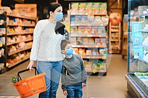 Authentic shot of mother and son wearing medical masks to protect themselves from disease making shopping for groceries