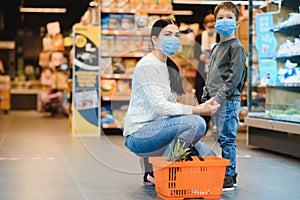 Authentic shot of mother and son wearing medical masks to protect themselves from disease making shopping for groceries