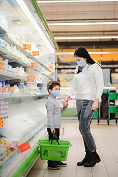 Authentic shot of mother and son wearing medical masks to protect themselves from disease while shopping for groceries