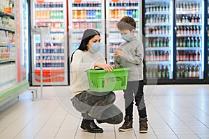 Authentic shot of mother and son wearing medical masks to protect themselves from disease while shopping for groceries