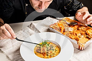 Authentic Spanish paella with cod and mussels. Traditional Mediterranean seafood dish. The chef decorates the dish with herbs