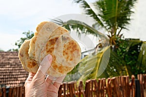 Authentic Sri Lankan three Pol Coconut Roti in hand.