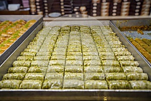 Authentic sweet Baklava wrap, traditional turkish famous delicious dessert in metal tray showcase of local shop in Istanbul