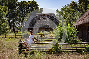 Authentic Ukrainian architecture. Woman outdoor. Ukrainian woman in summer village cottage. Ukraine folk authentic house. Thatched