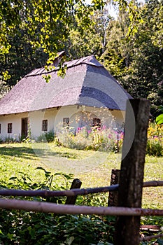 Authentic Ukrainian house in countryside. Summer village in Ukraine. Old folk thatched house. Ukrainian ethnographic traditional