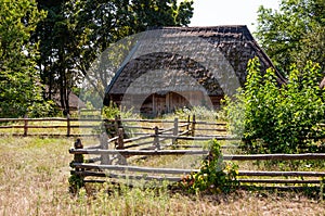 Authentic Ukrainian house in countryside. Summer village in Ukraine. Old folk thatched house. Ukrainian traditional rustic house.