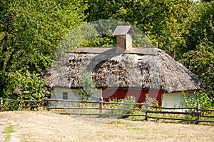 Authentic Ukrainian house in countryside. Summer village in Ukraine. Old folk thatched house. Ukrainian traditional rustic house.