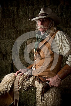 Authentic western cowboy with leather vest, cowboy hat and scarf portrait