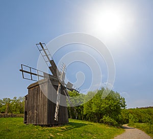 Authentic windmill among green fields at the sunny day