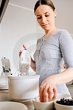 Authentic woman using a handheld mixer