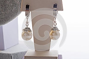 author beautiful earrings with pearls demonstrated around white backround. fashion and jewelry concept