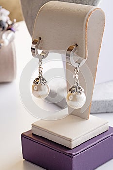 author beautiful pearl earrings demonstrated around white backround. fashion and jewelry concept