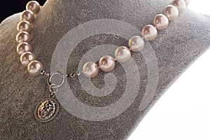 author beautiful soft pink pearls necklaces demonstrated on maneken. fashion and jewelry concept photo