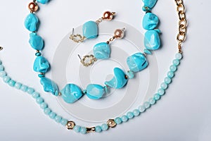 author collection jewelry with azure gemstones, pearls and chain demonstrated at white background. fashion and jewelry