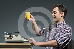 Author drinking coffee at typewriter