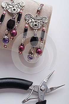 author ethno errings demonstrated with tool against white background. fashion and jewelry concept