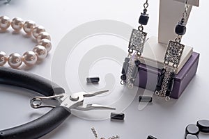 author ethno errings demonstrated with tool against white background. fashion and jewelry concept