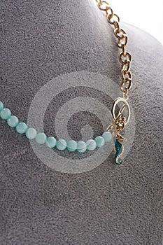 Author necklace with azure gemstones and chain demonstrated on maneken. close up. fashion and jewelry concept photo