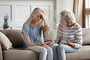 Authoritative mature mom lecturing frustrated grownup daughter