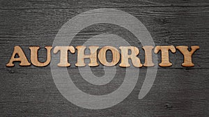 Authority word text, wooden alphabet lettering on dark background