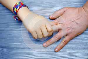 Autism Awareness Picture. Father holding hand her Autistic Child