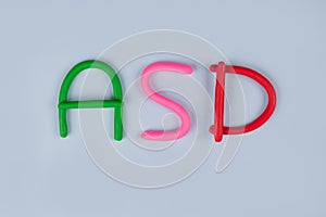 Autism spectrum disorder and World Autism Awareness Day concept - multicolored letters made of play-doh or other sensory playfoam