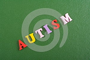 AUTISM word on green background composed from colorful abc alphabet block wooden letters, copy space for ad text. Learning english