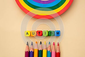 Autism word wooden colorful cubes and rainbow. Mental health, social suport. Special education concept