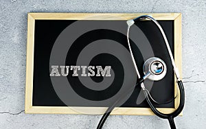 AUTISM word wrote on chalkboard with stethoscope
