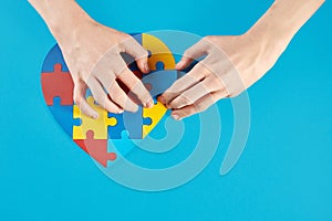 Autistic boy hands holding jigsaw puzzle heart shape. World Autism Awareness Day