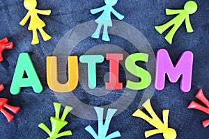 Autistic child concept with colorful plastic letter spelling autism on dark background