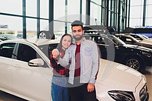 Auto business, car sale, consumerism and people concept - happy couple buying car in auto show or salon.