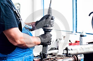 Auto car mechanic adjusting a car shock absorber