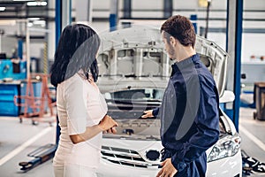 Auto car repair service center. The mechanic communicates with the client