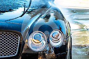 Auto detailer washing luxury high end car photo