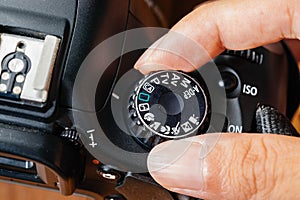 Auto dial mode on dslr camera with fingers on the dial