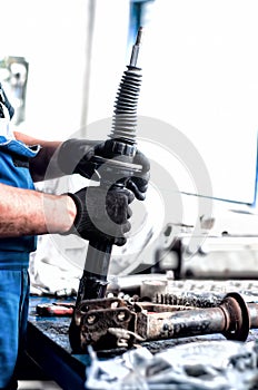 Auto engineer mechanic working on car shock absorber