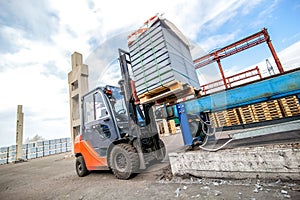 Auto loader with concrete blocks near house-building factory