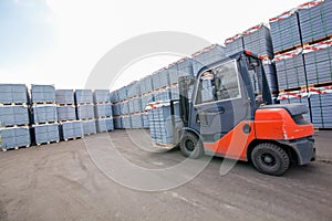 Auto loader with concrete blocks near house-building factory