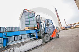 Auto loader with concrete blocks near house-building factory