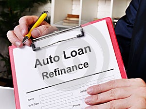 Auto loan refinance concept. Man offers to sign the document.