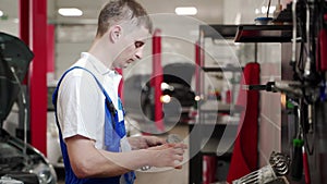 Auto mechanic assembles engine with precision in workshop. Technician installs pistons, rings in restoration process