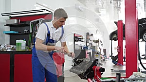 Auto mechanic assembles engine in workshop. Professional installs crankshaft, bearings in cylinder block. Car service