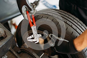 Auto mechanic balancing wheel, tire service