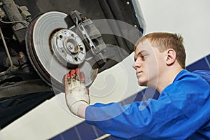 Auto mechanic at car brake shoes eximining