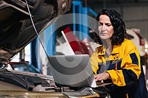auto mechanic car engineer using laptop computer tuning ECU diagnosis analysis monitor engine problem in garage auto service