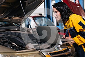 auto mechanic car engineer using laptop computer tuning ECU diagnosis analysis monitor engine problem in garage auto service