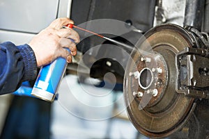 Auto mechanic at car suspension repair work