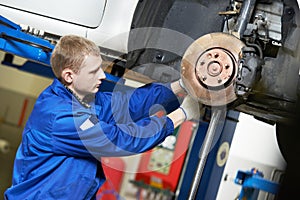 Auto mechanic at car suspension repair work