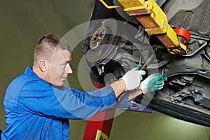 Auto mechanic at car suspension repairing